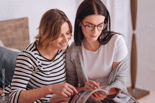 Interested beautiful ladies looking through an article