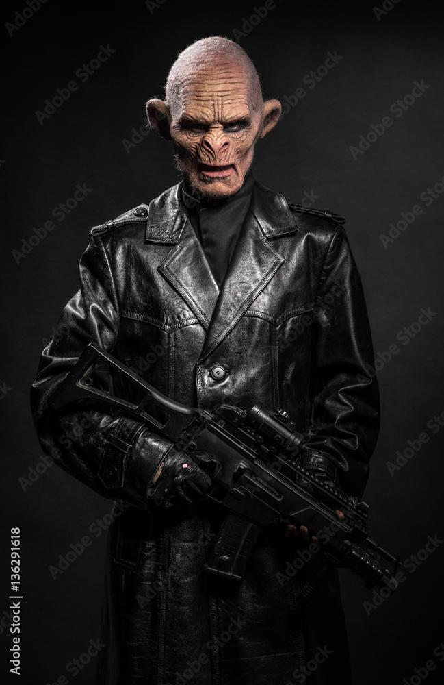 Angry baboonish man in black clothes on dark background Angry baboonish man in black clothes on dark background