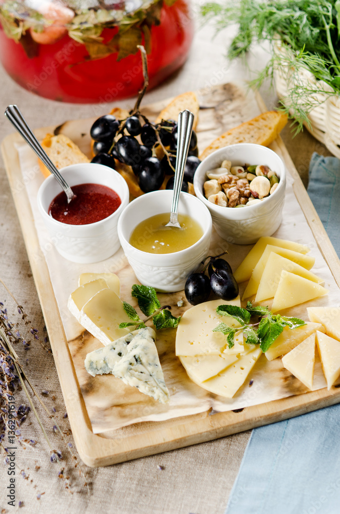 assorted cheeses with honey, jam, nuts and grapes assorted cheeses with honey, jam, nuts and grapes