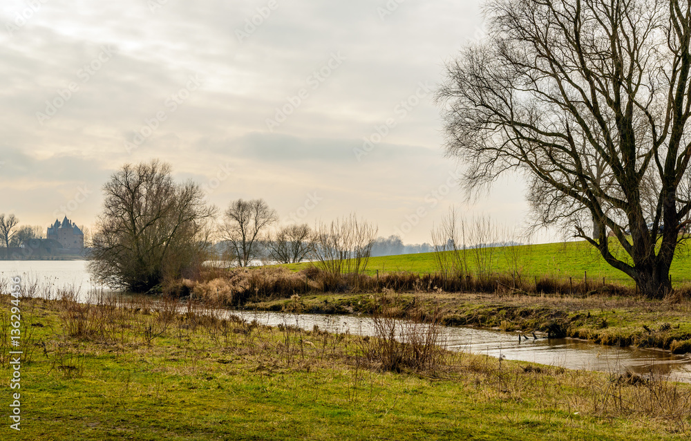 Picturesque Dutch river landscape with in the background castle