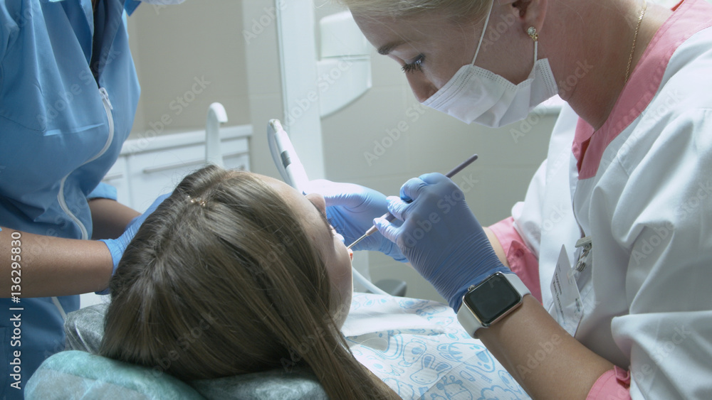 Beautiful girl on the examination by the doctor dentist Beautiful girl on the examination by the doctor dentist