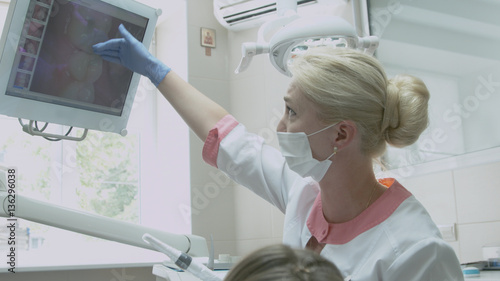 Dentist examining patient's teeth on the monitor