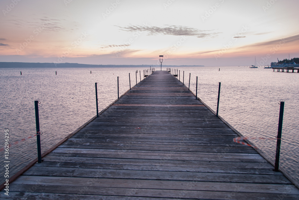 Wooden pier entering into the sea with colorful morning sky