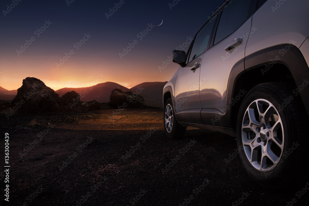 Close up of a car on a desert road at the sunset with copy space