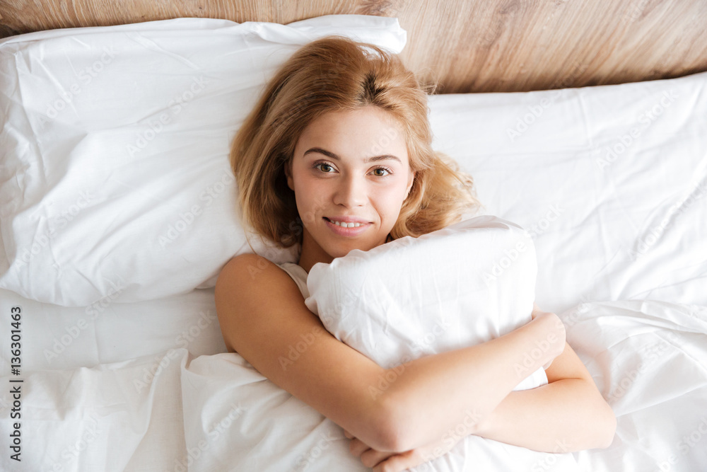 Top view of Smiling woman emracing with pillow Top view of Smiling woman emracing with pillow