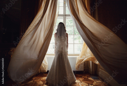 The charming bride stands near window in the restaurant © myronovychoksana