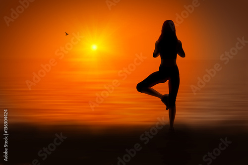 Silhouette of woman doing yoga at sunset