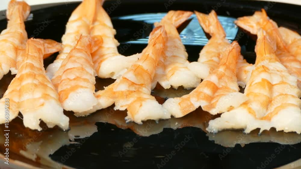 Large cooked shrimp spread on a black plate Large cooked shrimp spread on a black plate
