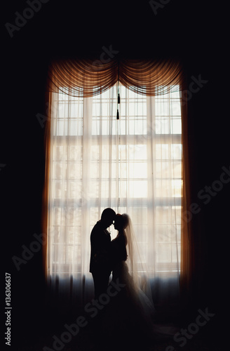 young lovers kissing on the background of window