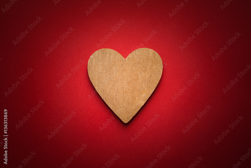 One Wooden Brown Heart On Red Paper Background With Vignette.
