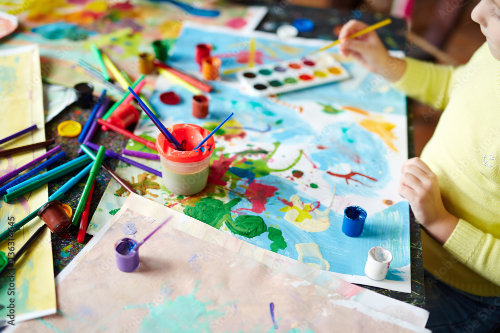 Fototapeta premium Picture drawn by gouache, objects for painting and little girl doing artwork