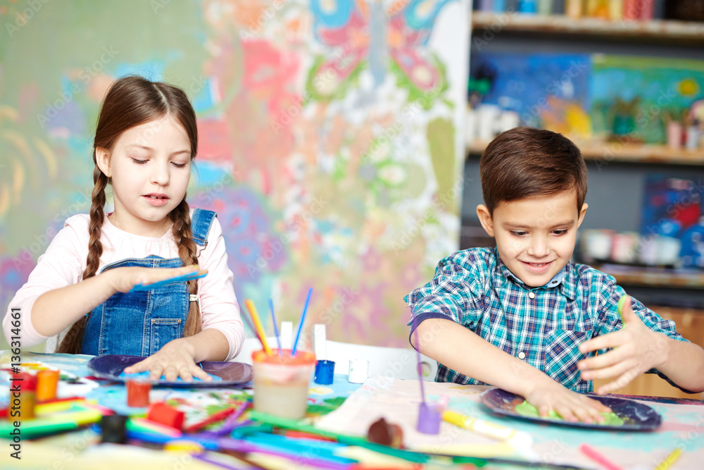 Two kids going to make palm prints Two kids going to make palm prints