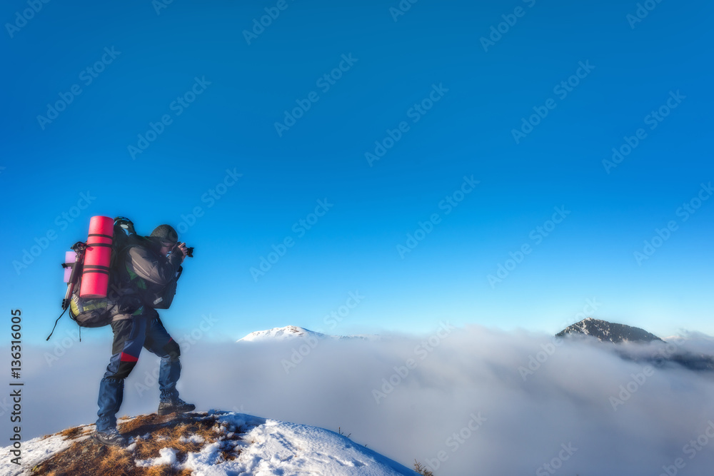 Photographer takes pictures on top of the mountain in winter