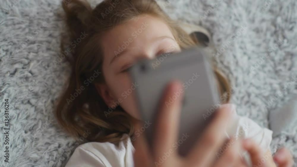 Little girl makes selfie photo on the phone in the home Little girl makes selfie photo on the phone in the home