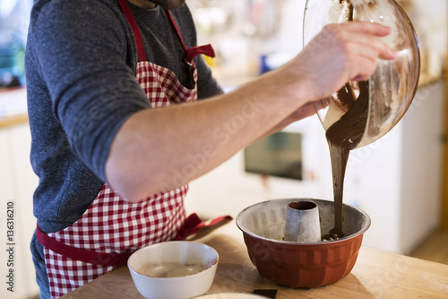 Wallpaper Mural Man standing in kitchen baking chocolate cake Torontodigital.ca