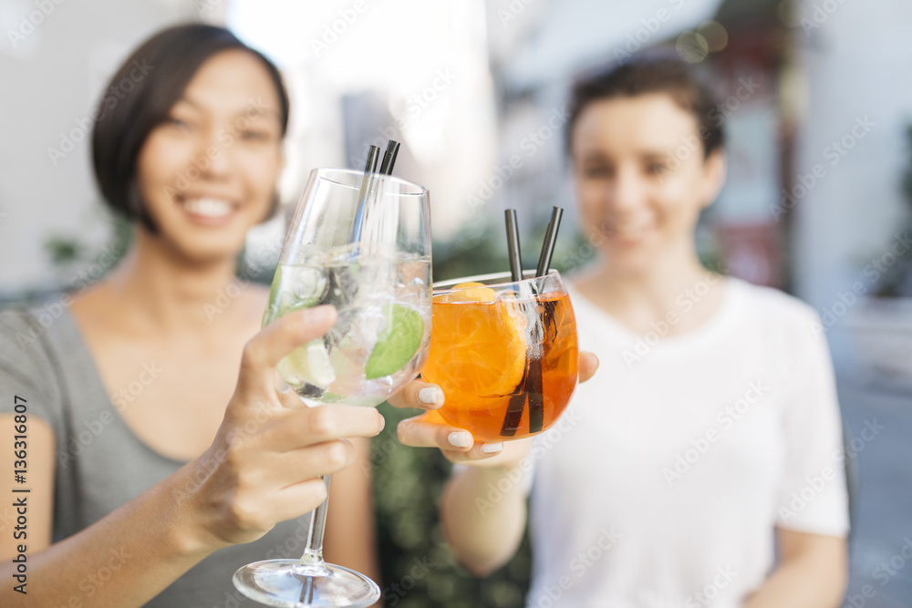 Two young women toasting with cocktails, close-up Two young women toasting with cocktails, close-up