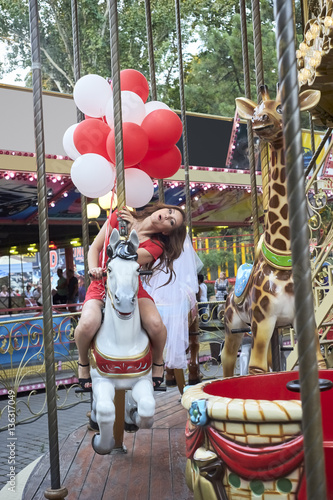 Bride with balloons rides on the carousel