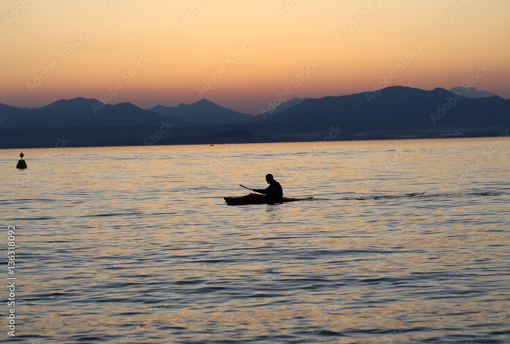 Lonely paddler on the lake during the sunset Lonely paddler on the lake during the sunset