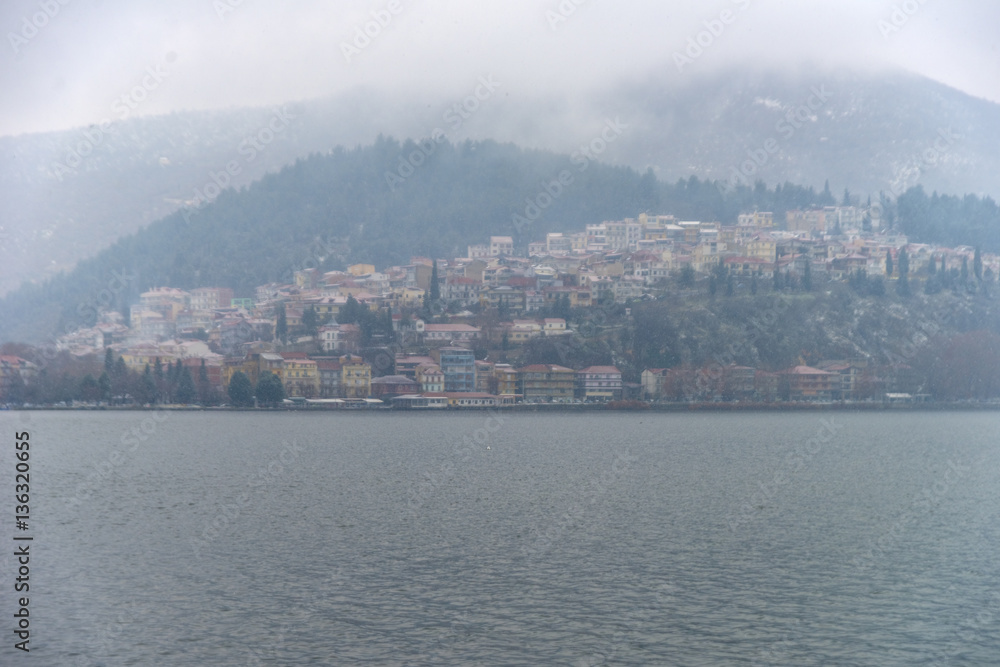 Foggy winter scenery at the lake of Kastoria Greece, during a he