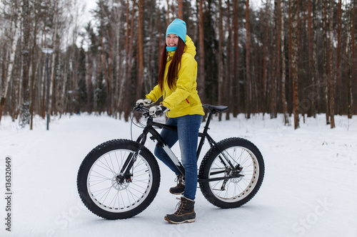 Photo of young girl in yellow jacket at winter cycling