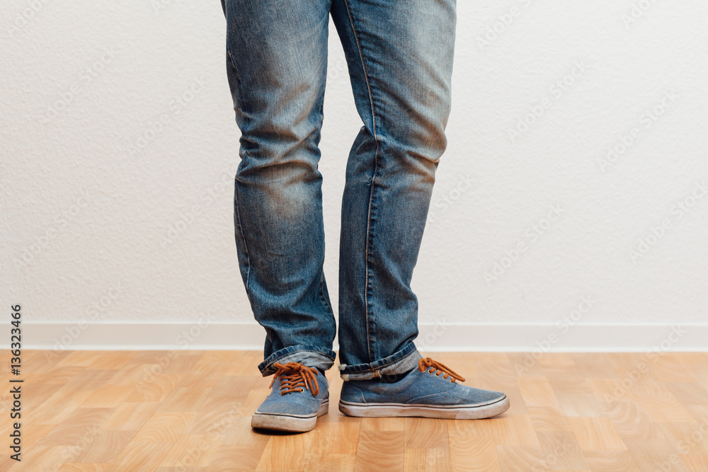 Mann steht mit gespreizten Füssen, untere Körperhälfte Mann steht mit gespreizten Füssen, untere Körperhälfte