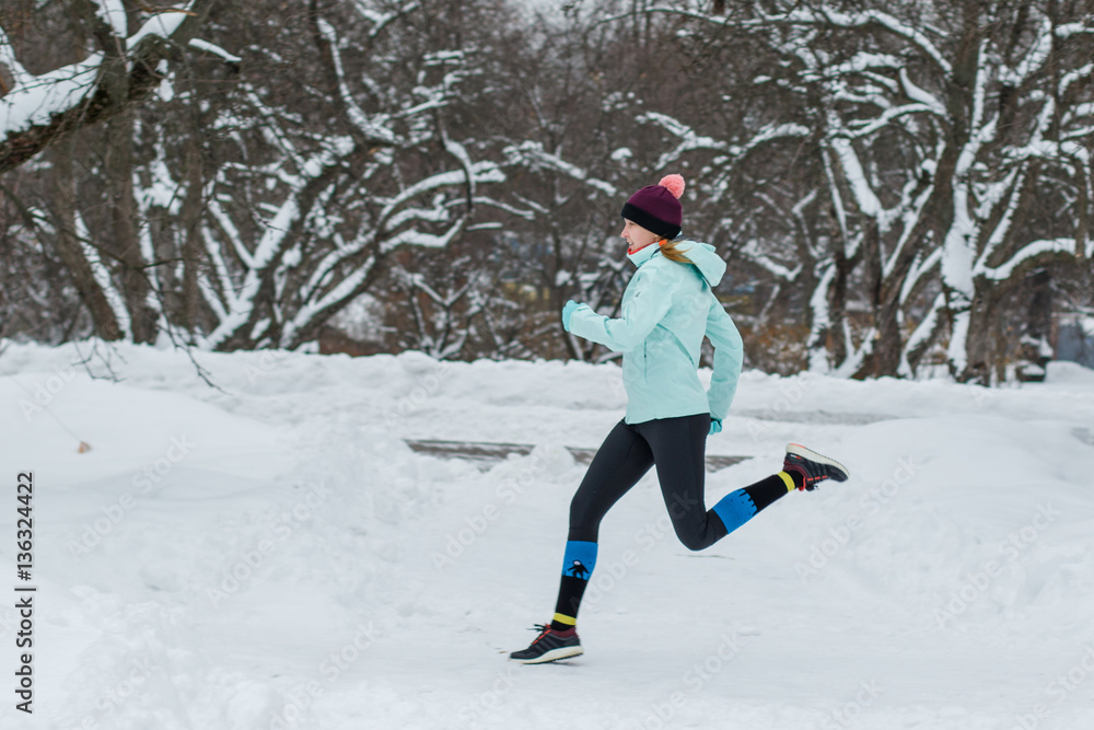 Young woman jogging in the winter park Young woman jogging in the winter park