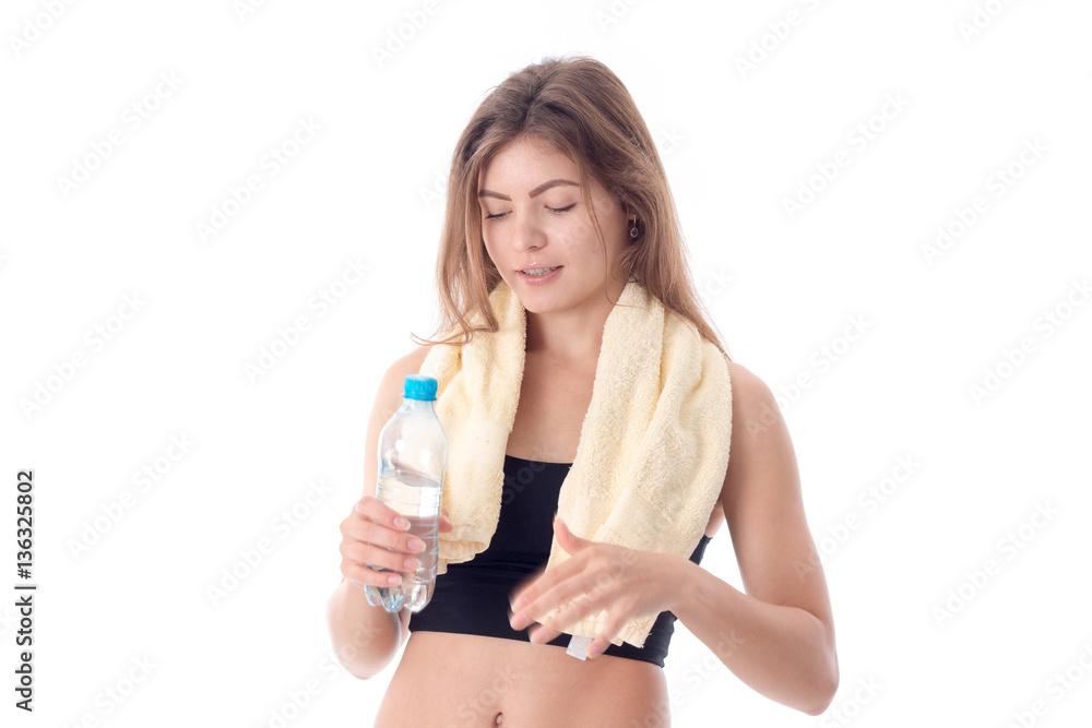 young athletic girl with towel on his shoulders holding bottle of water in hand isolated white background young athletic girl with towel on his shoulders holding bottle of water in hand isolated white background