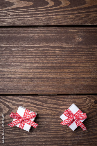 White gift boxes with red ribbon on wooden table. Top view