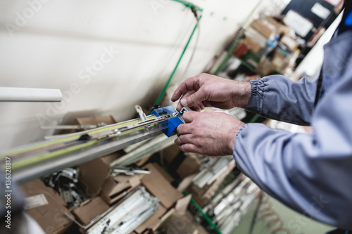 Manual worker assembling PVC doors and windows. Manufacturing jobs. Selective focus. Factory for aluminum and PVC windows and doors production. © Dusko
