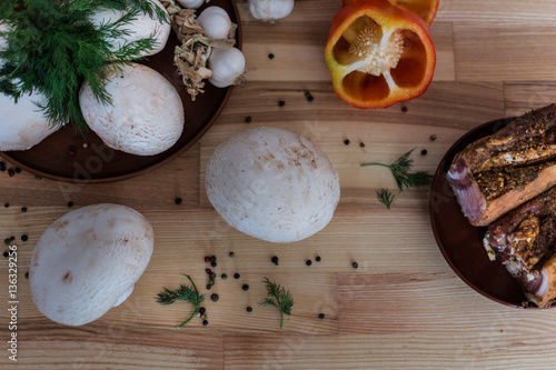 Mushrooms and homemade Ukrainian bacon on the wooden background with garlic and pepper