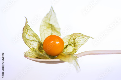 Orange organic physalis in wooden spoon i photo