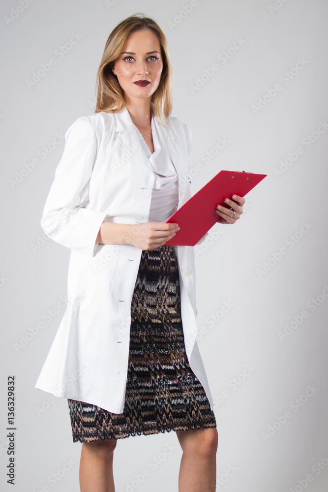 Portrait of happy young smiling female doctor holding a medical record clipboard Portrait of happy young smiling female doctor holding a medical record clipboard