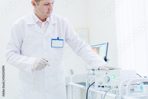 proctologist doctor holding Ligador hemorroidal in office photo