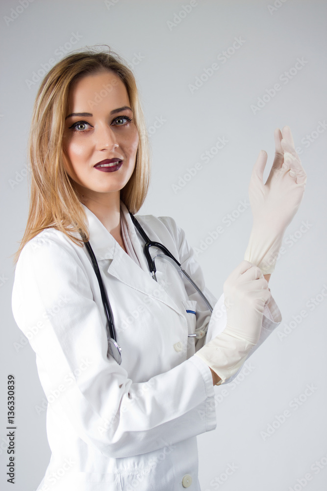 Beautiful female Doctor putting medical gloves Beautiful female Doctor putting medical gloves