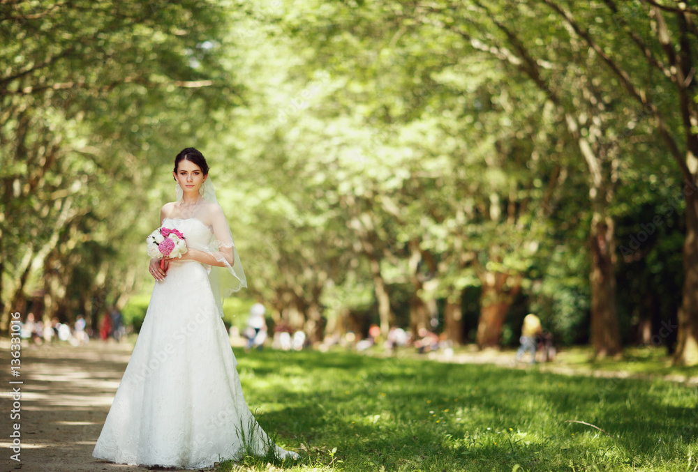 the luxurious young bride with a bouquet of peonies in hand
