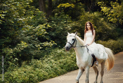Bride riding elegant withe horse in the quite park