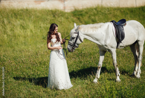 Bride with a white horse on the grass © myronovychoksana