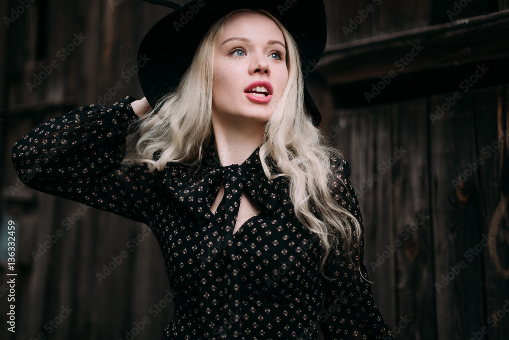 Beautiful attractive and stylish girl wearing black hat standing posing in city. Nude makeup, best daily hairstyle and great fashion glamour country style.