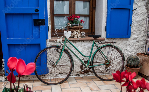 Vintage old bicycle in front of cute flowered house in Spain photo