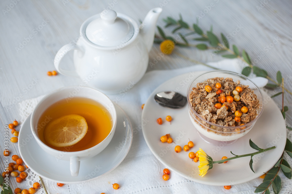 Serving table for breakfast: tea with lemon, granola and tea pot. Serving table for breakfast: tea with lemon, granola and tea pot.