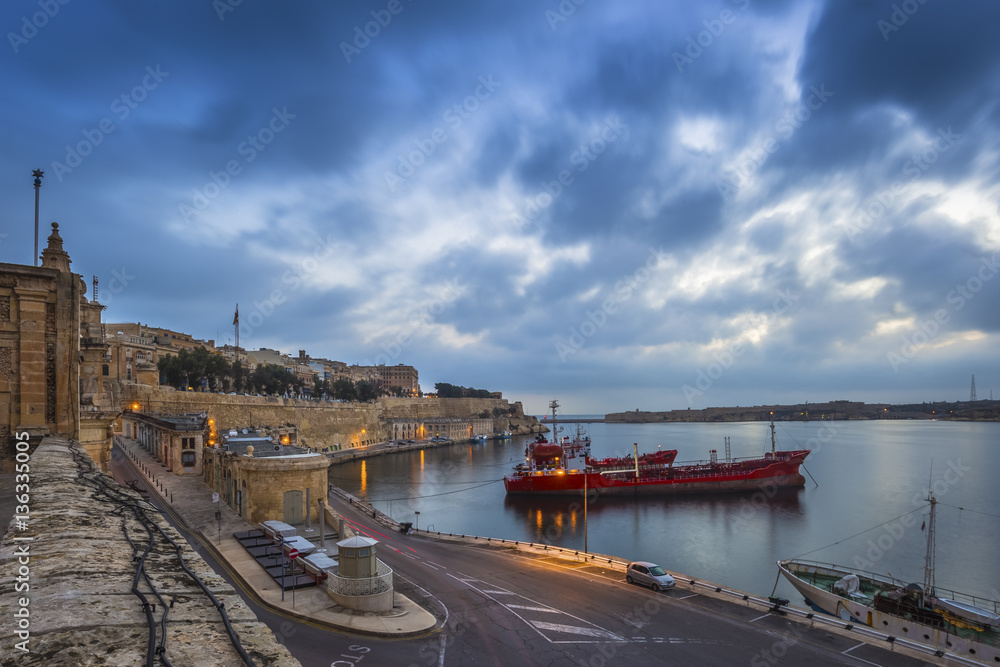 Valletta, Malta - Beautiful dawn and morning lights at the ancient walls of Valletta waterfront with ships and nice blue clouds