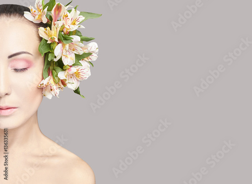Beautiful Nude attractive brunette with flowers on his head. Fashion beautiful makeup, clean skin, facial care. Portrait of young beautiful woman with perfect skin © angel_nt