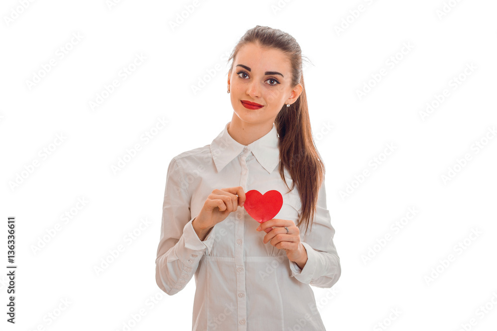 Lovely young brunette woman with red heart in hands posing isolated on white background. Saint Valentine's day concept. Love concept. Lovely young brunette woman with red heart in hands posing isolated on white background. Saint Valentine's day concept. Love concept.