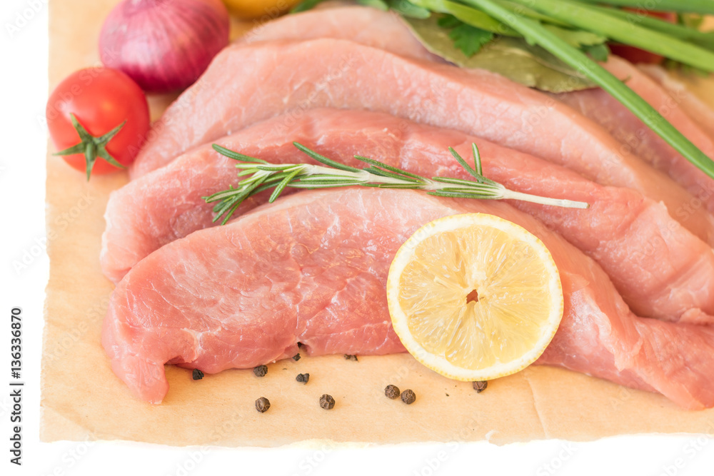 Sliced pork with vegetables and spices on paper. Sliced pork with vegetables and spices on paper.