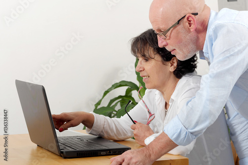 Portrait of a happy senior couple using laptop © Philipimage