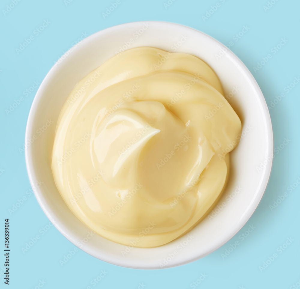 Bowl of mayonnaise on blue background; from above Bowl of mayonnaise on blue background; from above
