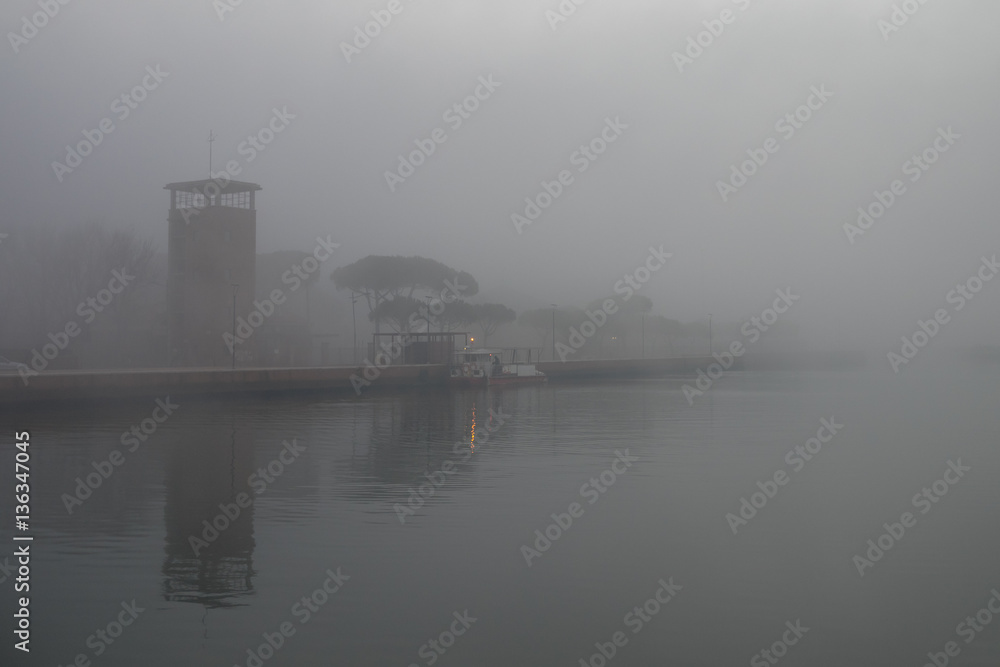 Naklejka premium Small ferry docked in a foggy day