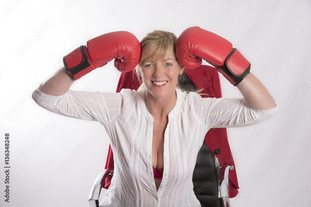 Officer worker wearing red boxing gloves seated on a chair Officer worker wearing red boxing gloves seated on a chair
