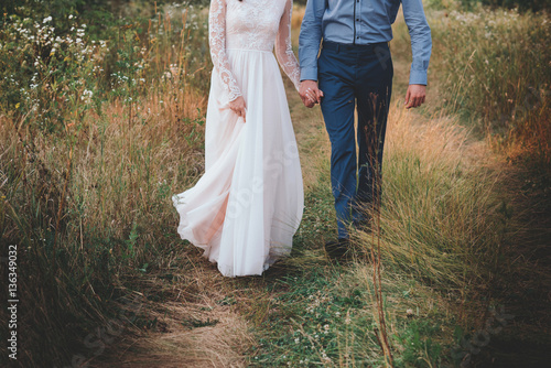 Couple having a date, holding hands and kissing or hugging.Unrecognizable people, closeup of legs.