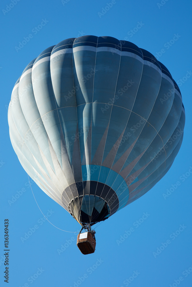 Fototapeta premium Hot air balloon, blue tones aerostat on clear sky